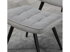 Sillón con taburete en terciopelo gris claro, patas de metal negro.