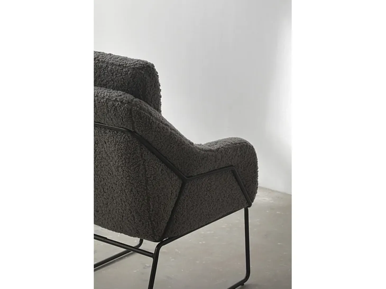 Sillón tapizado color gris con patas metálicas negras